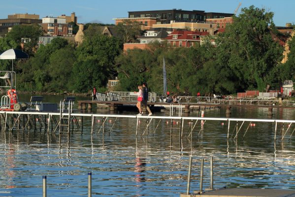 Couple walks on dock at Lake Mendota, University of Wisconsin, Madison, Wisconsin.